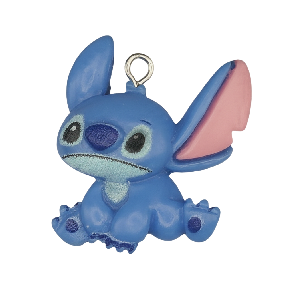 close-up of blue alien character charm with pink ears on a black background
