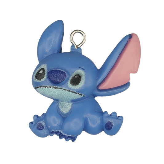 close-up of blue alien character charm with pink ears on a black background