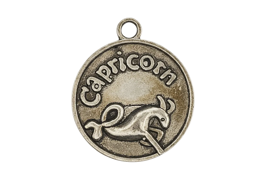 Close-up of round bronze charm with 'Capricorn' text and sea-goat symbol.
