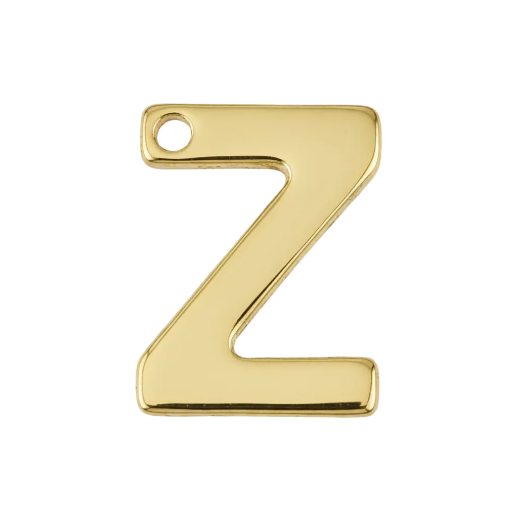 Close-up of a small gold letter Z charm on a black background.