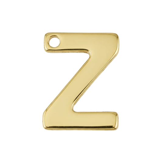 Close-up of a small gold letter Z charm on a black background.