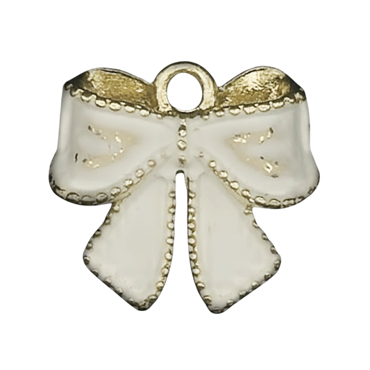 close-up of a white enamel bow charm with gold accents on a black background
