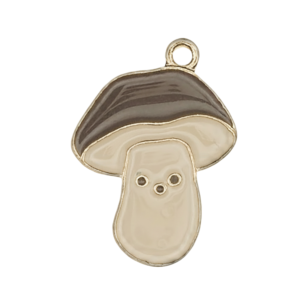 Close-up of a gold-tone enamel mushroom charm with brown cap and cream stem on a black background.