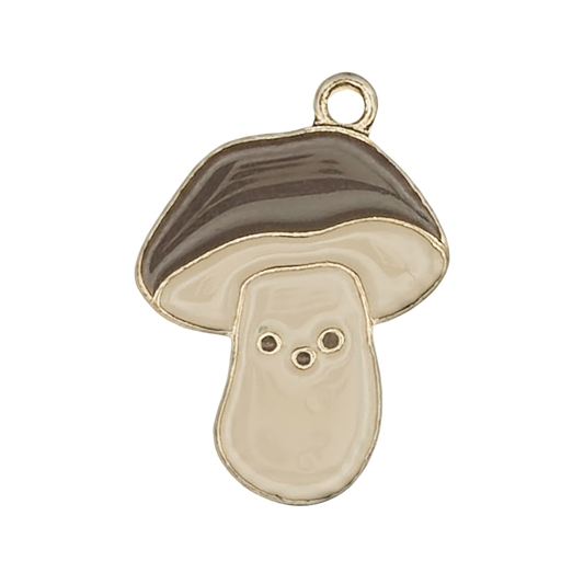 Close-up of a gold-tone enamel mushroom charm with brown cap and cream stem on a black background.
