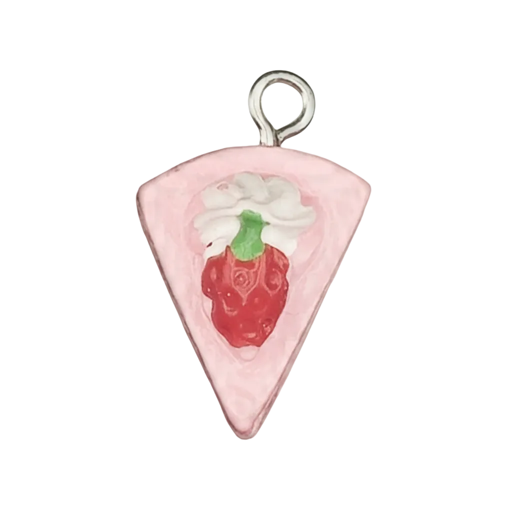 close-up of a pink cake slice charm with a red strawberry and white cream on a black background