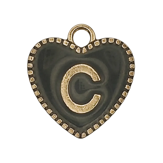 Close-up of black heart-shaped charm with gold letter C and dotted border.