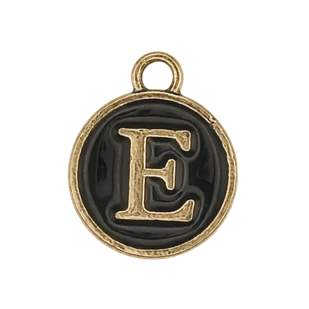 close-up of round black enamel charm with gold letter E