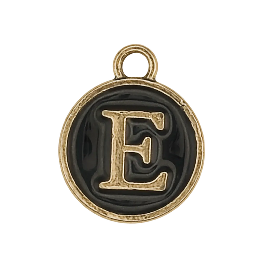 close-up of round black enamel charm with gold letter E