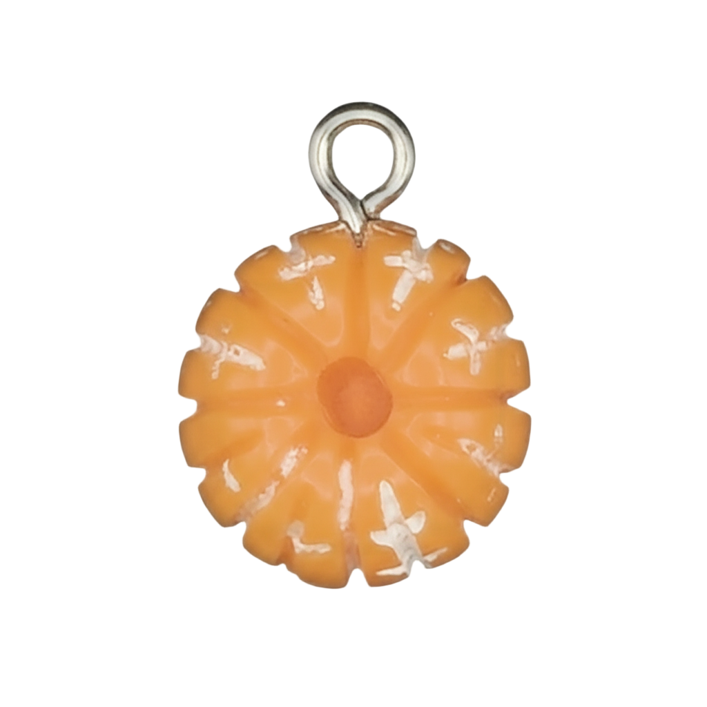 close-up of small orange enamel flower charm on black background