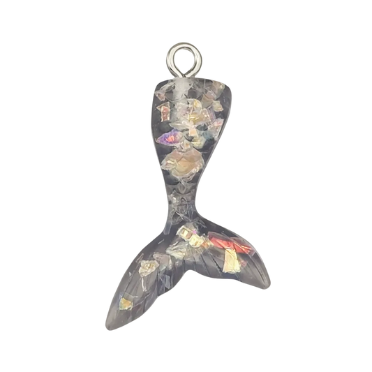close-up mermaid tail charm in black resin with multicolor flakes on black background