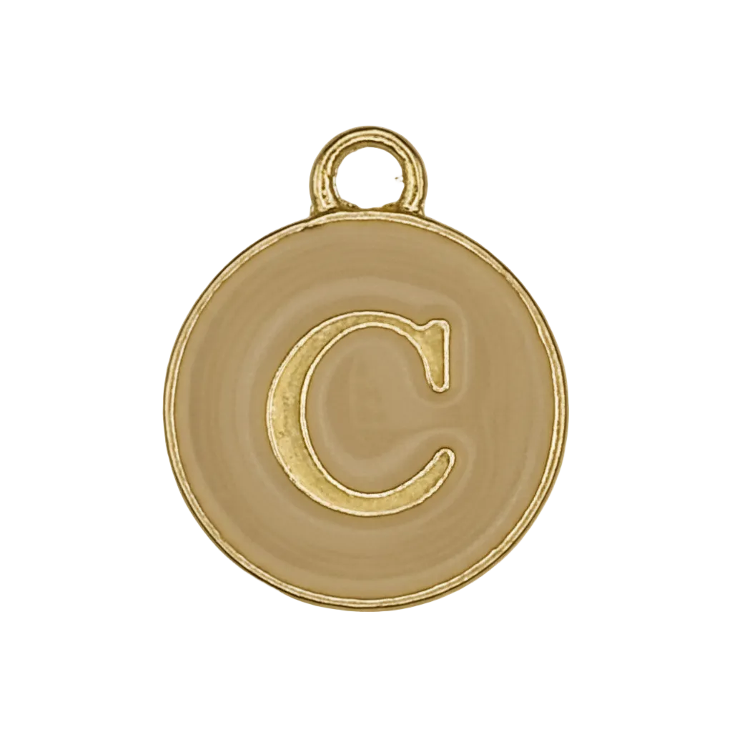 Close-up of round gold-tone charm with letter C on beige background