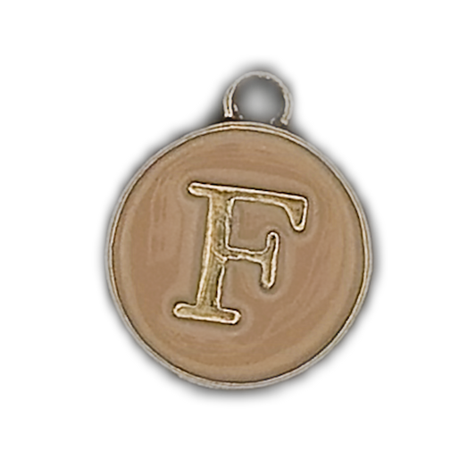 close-up of round beige charm with gold letter F