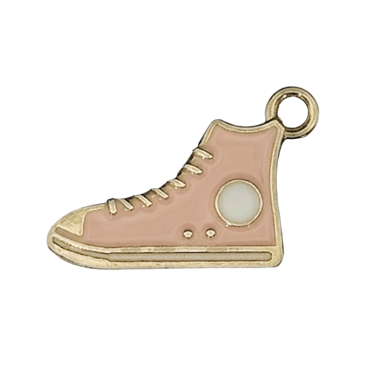 close-up of pink enamel high-top sneaker charm with gold outline and white patch