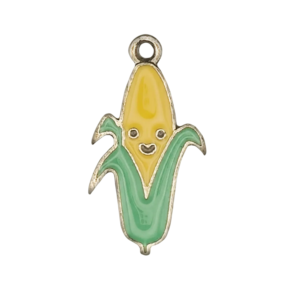 Close-up of enamel corn charm with smiling face on black background.