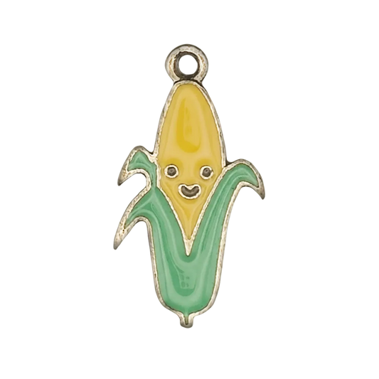 Close-up of enamel corn charm with smiling face on black background.