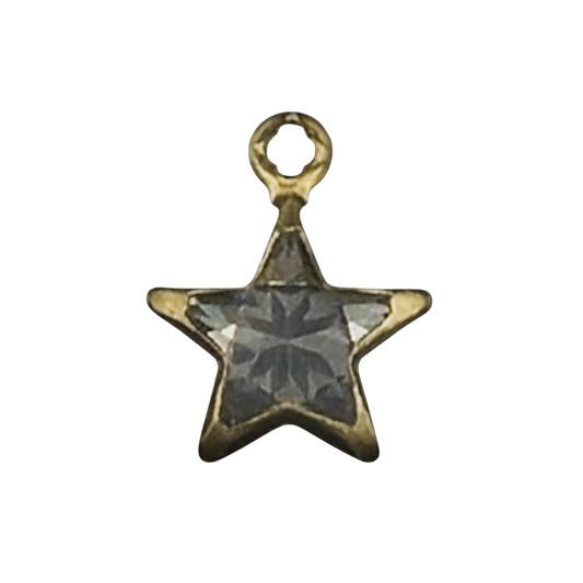 close-up of a small gold-tone star charm set with a gray faceted stone on a black background