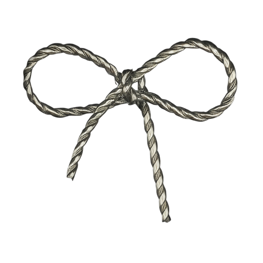 close-up of silver rope-textured bow charm on black background