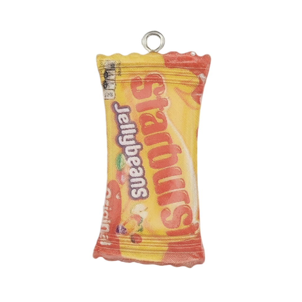 close-up of yellow jellybeans candy bag charm with red and orange accents on a black background