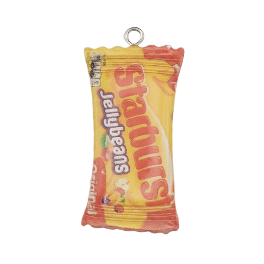 close-up of yellow jellybeans candy bag charm with red and orange accents on a black background