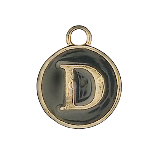 close-up of round black enamel charm with gold letter D