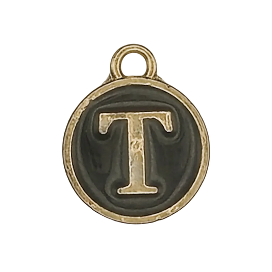 close-up of round gold-tone charm with letter T on black background