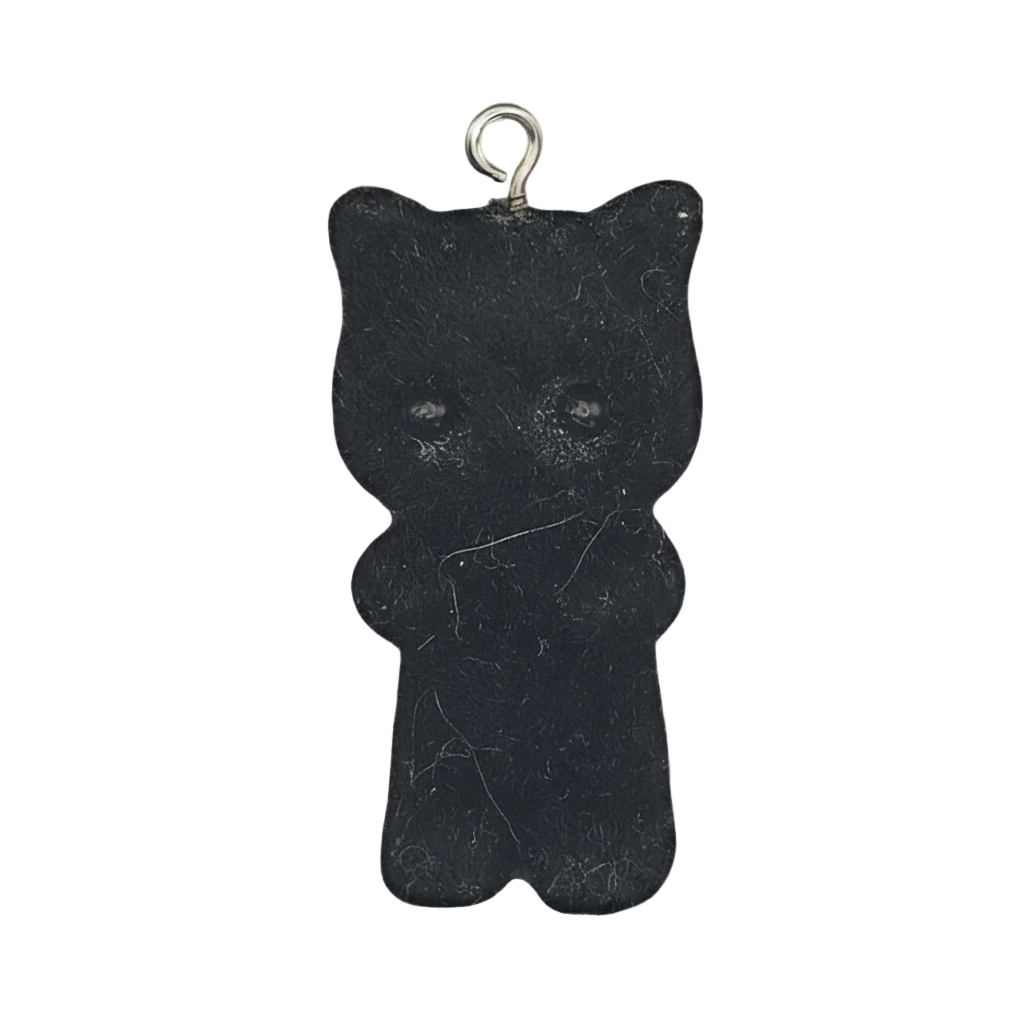 black gummy bear charm with small metal loop on a black background