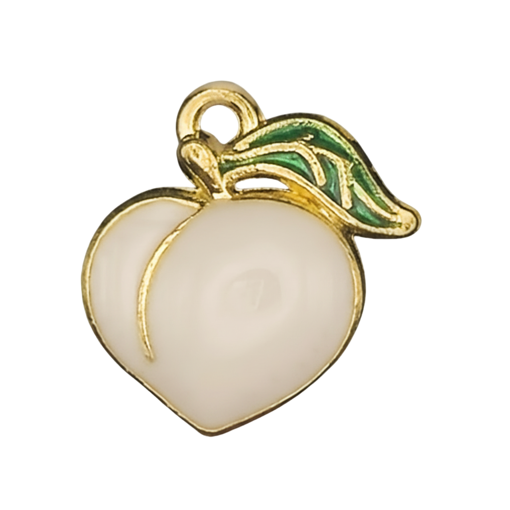 close-up of a white enamel peach charm with a green leaf and gold-tone outline on a black background