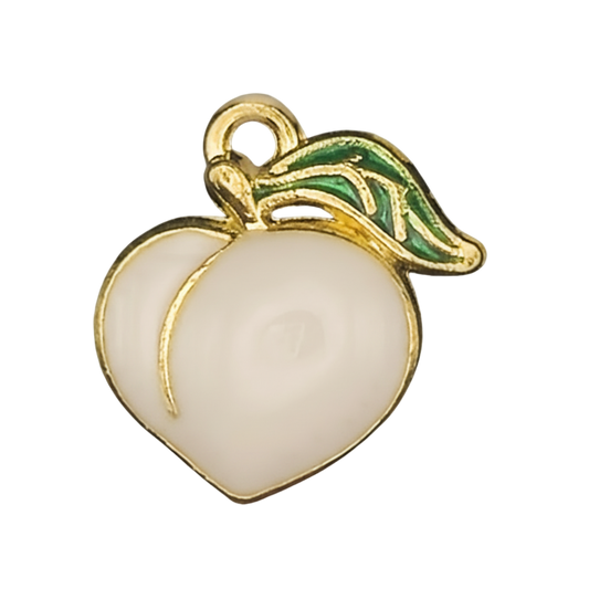 close-up of a white enamel peach charm with a green leaf and gold-tone outline on a black background