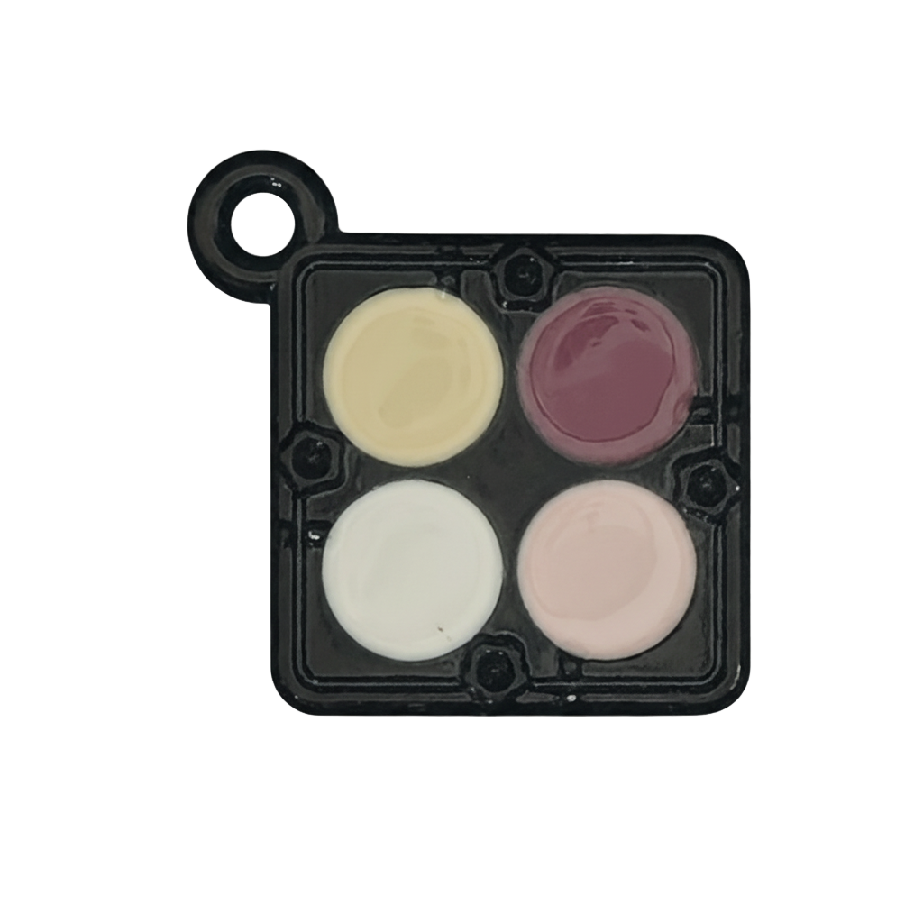 Close-up of black mini eyeshadow palette charm with four pastel enamel pans.