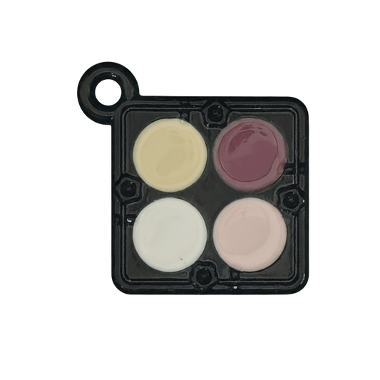 Close-up of black mini eyeshadow palette charm with four pastel enamel pans.