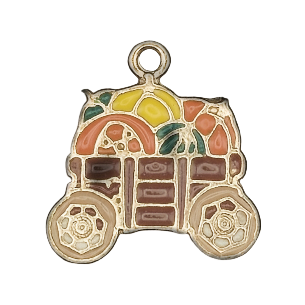 Close-up of a gold-tone enamel charm shaped like a fruit cart with colorful fruit and two wheels.
