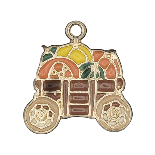 Close-up of a gold-tone enamel charm shaped like a fruit cart with colorful fruit and two wheels.