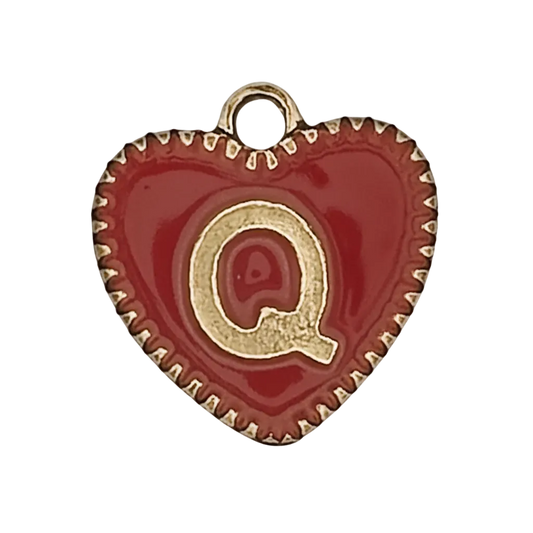 close-up of red enamel heart charm with gold letter Q and dotted gold edge on black background
