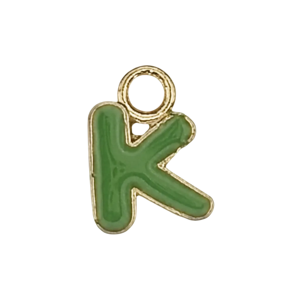 close-up of small green letter K charm with gold outline on black background