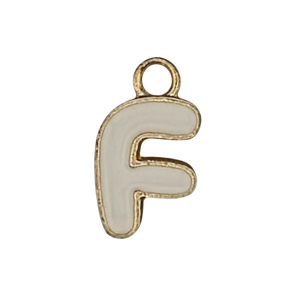 close-up of white enamel letter F charm with gold-tone outline on black background