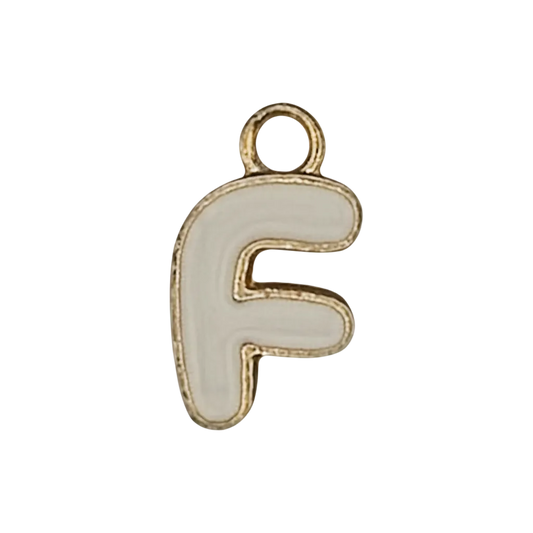 close-up of white enamel letter F charm with gold-tone outline on black background
