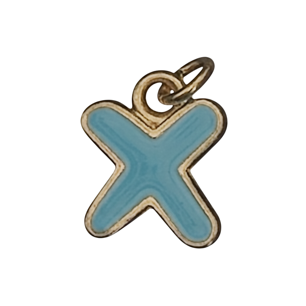 close-up of a small blue letter X charm with gold-tone trim on a black background