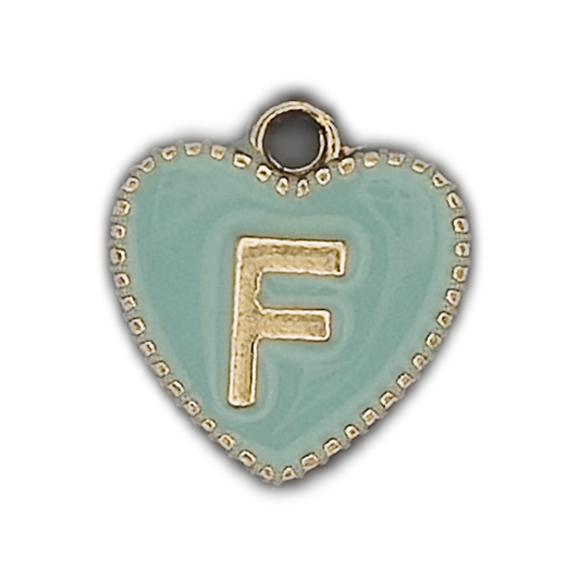 Close-up of mint heart charm with gold letter F and dotted border on black background.