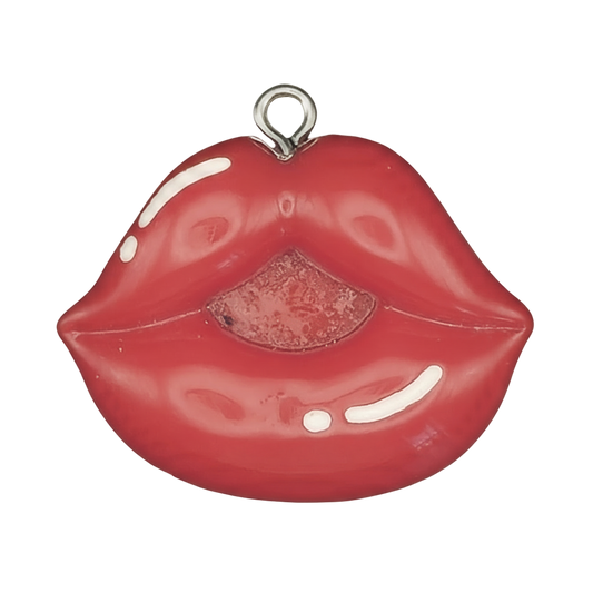 Close-up of a red lips-shaped charm on a black background.