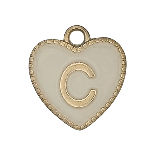 Close-up of a white enamel heart charm with a raised gold-tone letter C and beaded border.
