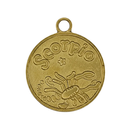 close-up of gold round charm with 'Scorpio' and scorpion engraving