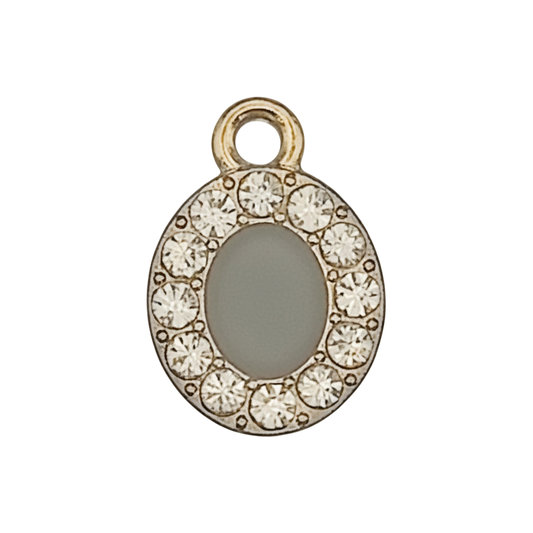 close-up of a small gold-tone letter O charm with clear stones on a black background