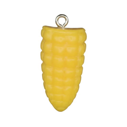Close-up of a small yellow corn cob charm on a black background.